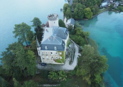 Le château de Duingt et les eaux turquoise du lac d'Annecy vus de la montgolfière