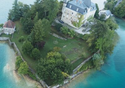 Le château de Duingt et les eaux turquoise du lac d'Annecy vus de la montgolfière