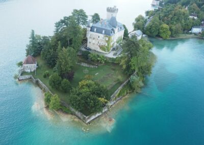Le château de Duingt et les eaux turquoise du lac d'Annecy vus de la montgolfière