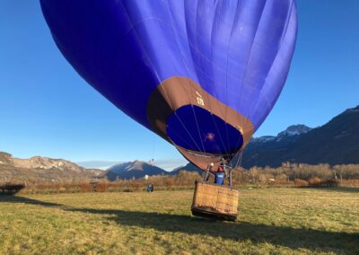 La montgolfière bleue d'Aero-Mountains décolle dans la lumière du matin