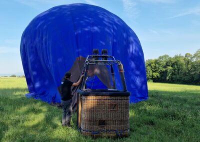 Gonflage de la montgolfière bleue dans un pré ensoleillé