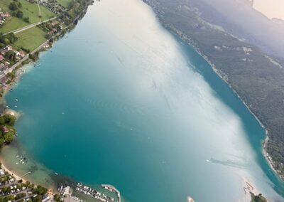 Le sud du lac d'Annecy vu du ciel, avec des montgolfières au loin