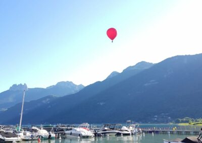 Une montgolfière au-dessus d'un port du lac d'Annecy