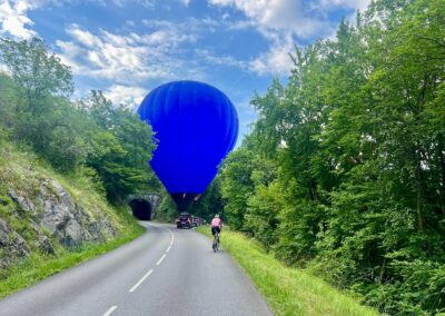La montgolfière bleue au-dessus d'une route de montagne