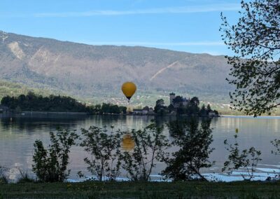 Une montgolfière au-dessus du château de Duingt, reflétée dans le lac