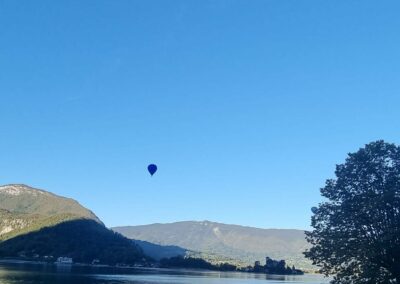 Une montgolfière au loin au-dessus du lac d'Annecy